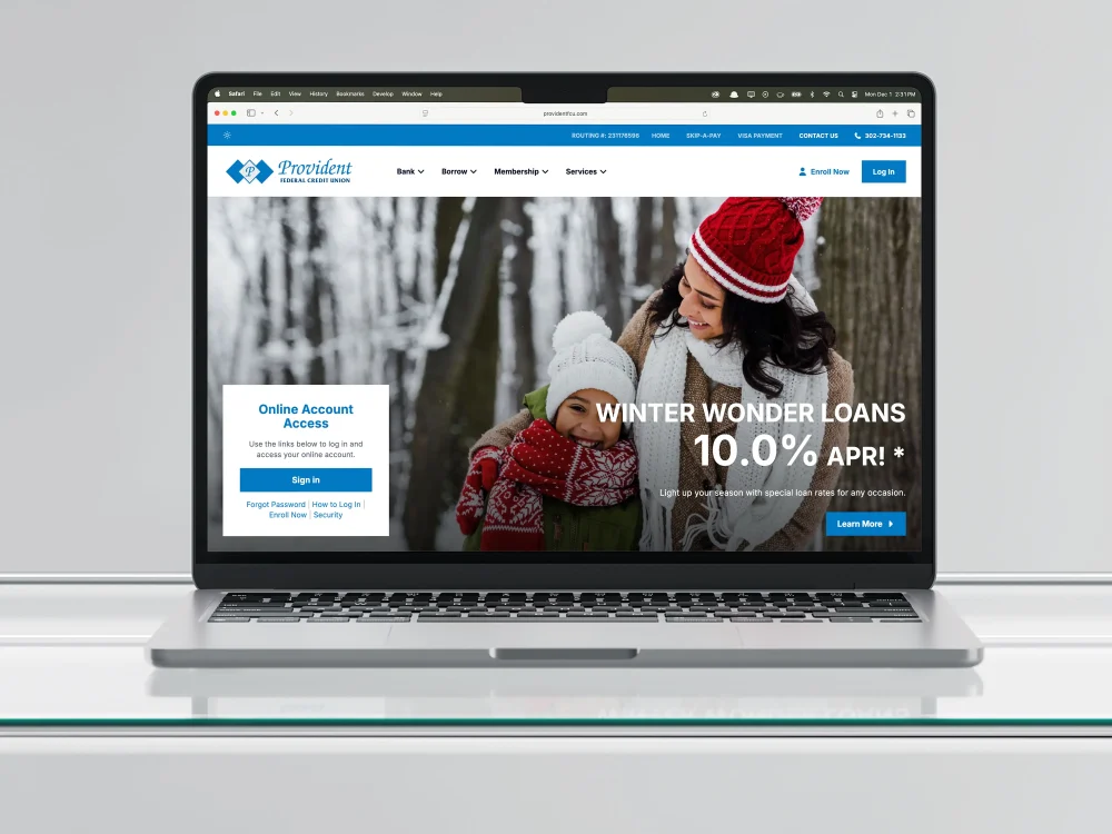 A laptop displaying the home page of the Provident Federal Credit Union website.